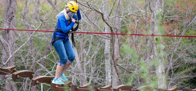 Masked female on Air Hike ropes course